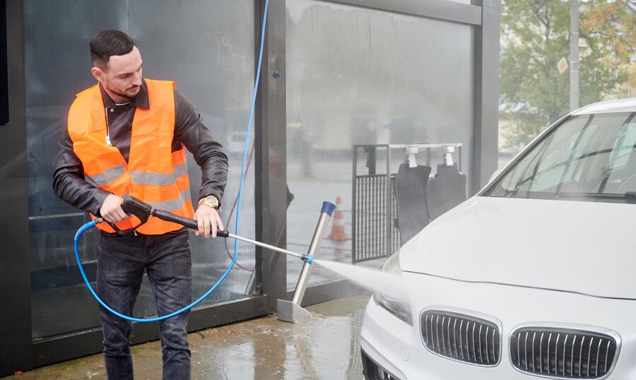 man-washing-car-carwash-station-wearing-orange-vest_651396-2008