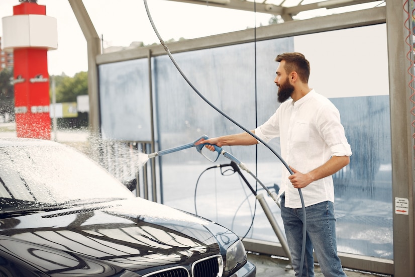 man-washing-his-car-washing-station_1157-27217